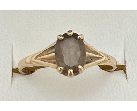 A vintage 9ct gold dress ring set with central oval cut smoked quartz. With claw setting and decorative detail to shoulders. 