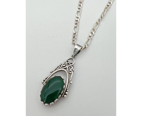 A silver rotating fob pendant set with onyx and green stone on an 20" silver 3mm figaro curb chain. Pendant stamped 925 on ba