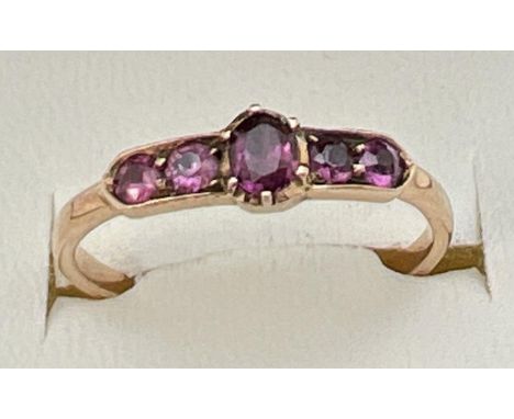 A vintage Art Deco unmarked 18ct gold and amethyst ring. Central oval cut stone flanked by 2 pairs of round cut amethysts in 