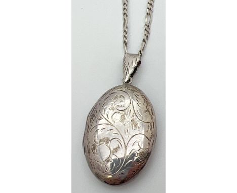 A large vintage silver oval shaped locket with engraved foliate &amp; scroll design. On an 18" silver 2mm figaro curb chain w