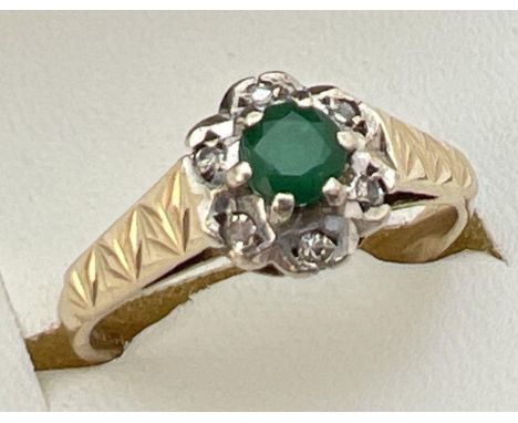 A vintage 9ct gold, emerald and diamond cluster ring with engraved detail to shoulders. Fully hallmarked inside band. Ring si