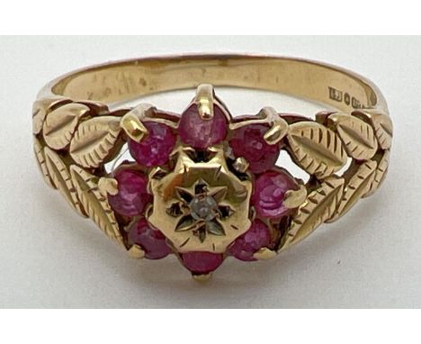 A vintage 9ct gold, ruby and diamond dress ring in a flower shaped setting. Central diamond surrounded by 8 small rubies and 