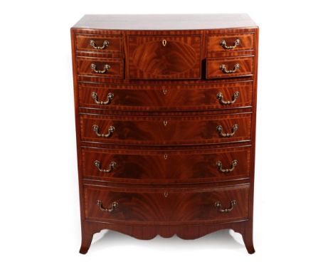 A Reproduction Mahogany Bowfront Chest of Drawers, in Regency style, with four small drawers surrounding a central deep drawe