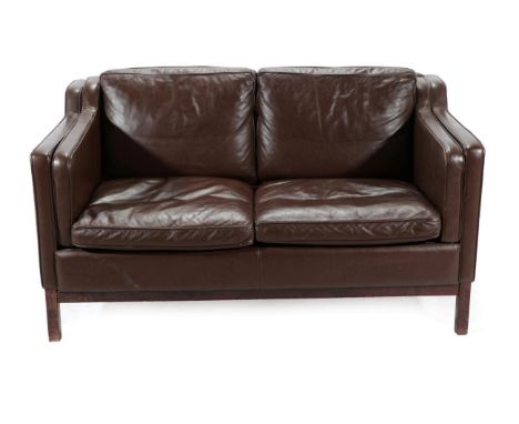 A Danish Design Two-Seater Sofa, covered in brown leather, with padded back support and arms, on square form legs, 138cm by 8