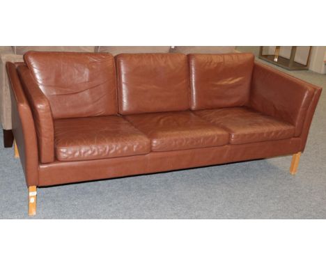 A 1970's Danish Design Three-Seater Sofa, upholstered in brown leather, with padded back support and arms, with eight cushion