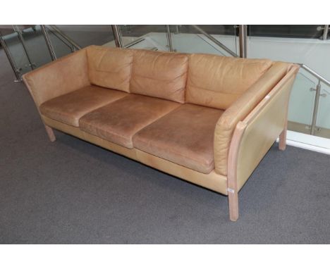 A 1970's Danish Stouby Three-Seater Sofa, covered in light tan leather, with padded back support and eight cushions, 202cm by