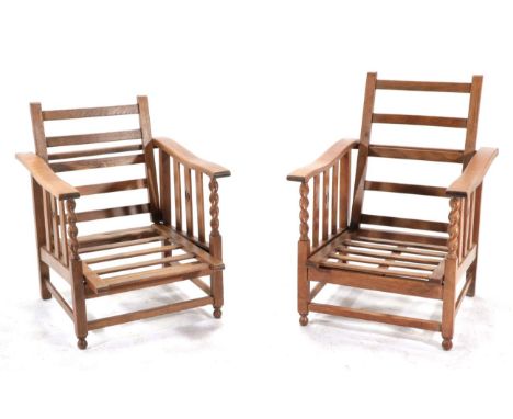 A Pair of Early 20th Century Oak Reclining Armchairs, the hinged and pivoting ladder back supports between rectangular form a