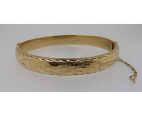 A 9ct gold hinged bangle with engraved decoration, 10g 
