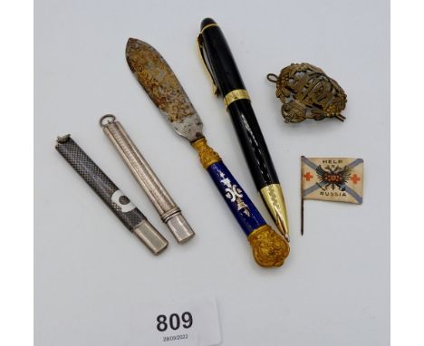 A niello chequer pencil holder and a white metal pencil holder, an enamel handled paper knife a/f, an RAF cap badge and Gamag