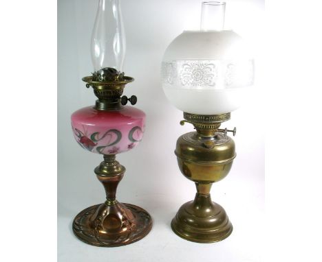 An Edwardian copper Art Nouveau oil lamp with painted pink glass reservoir and a brass oil lamp with etched glass globe shade