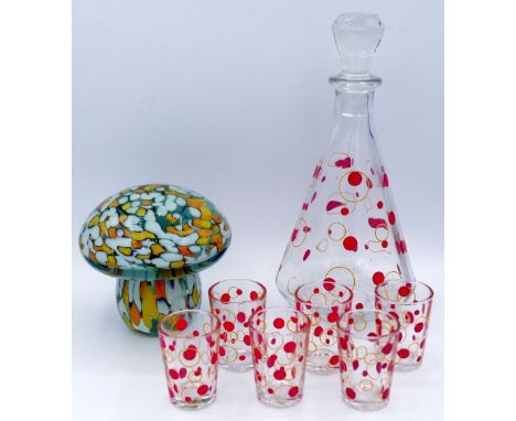 A vintage glass decanter and six liqueur glasses with polka dot decoration and a glass paperweight in form of a mushroom 