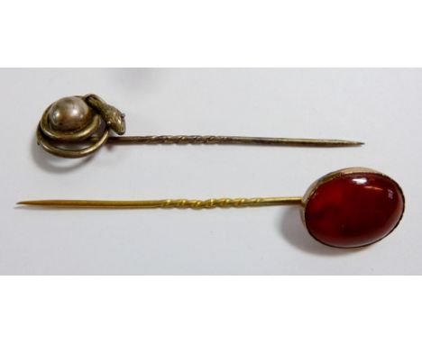 A yellow metal stick pin set agate and a snake stick pin 