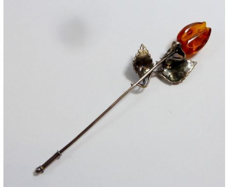 A vintage white metal and amber rose form stick pin 