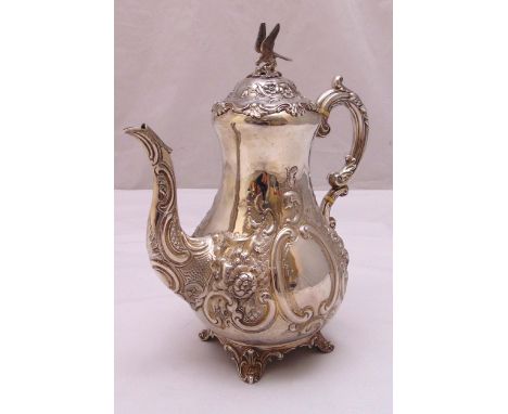A Victorian hallmarked silver coffee pot, pear shaped profusely chased with flowers, scrolls and leaves, leaf capped double s