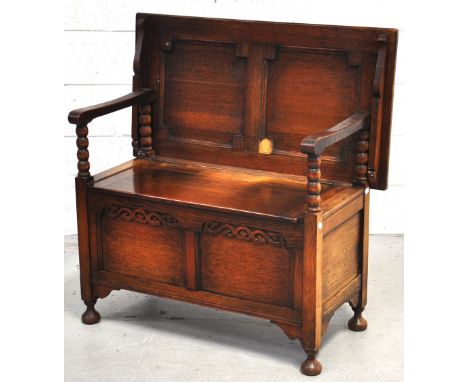 An early 20th century oak monks bench with hinged boxed seat and bun feet.