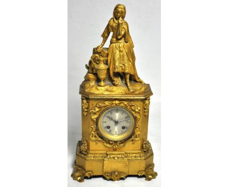 A mid 19th century French gilt metal mantel clock, the figural surmount modelled as a young woman beside an urn with circular