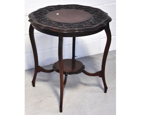 An early 20th century circular shaped occasional table with incised decoration to the top and a central lower shelf, diameter