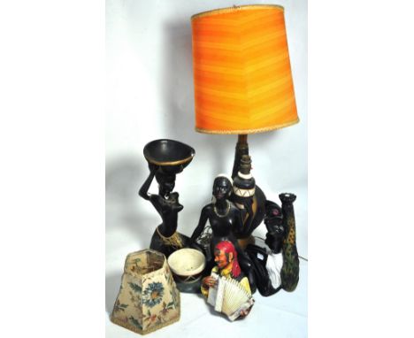 A retro black and brown baluster lamp with an orange card shade, a Bossons wall plaque and three figures of naked ladies, one