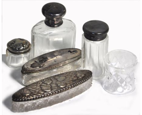 A hallmarked silver oval cut glass trinket box with Art Nouveau top decorated with cherubs, two cut glass dressing table bott