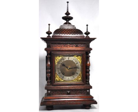 A late 19th century German carved oak cased eight day mantle clock, the pagoda top above square dial set with silvered chapte