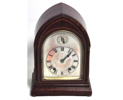 An Edwardian mahogany boxwood strung lancet shaped mantel clock, the arched silvered dial set with Roman numerals to the chap