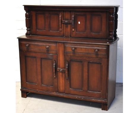 A 20th century Ercol style oak dresser/sideboard with an upper two door cabinet with interior shelf and two drawers above two