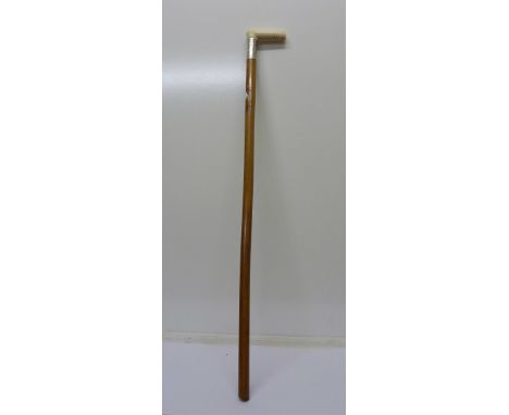 A walking stick with ivory handle and silver collar