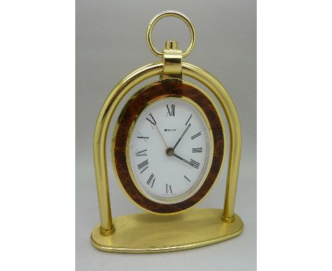A Swiza brass and enamel oval mantel clock