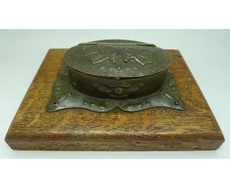 A piece of trench art mounted as a table snuff box on a wooden base