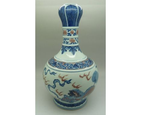 A fine Chinese mallet shaped garlic lipped vase, well painted in blue with playful Buddhist lions chasing ribbon-tied brocade