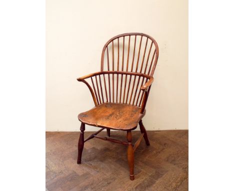 An antique elm tub shaped Windsor stick back elbow chair 