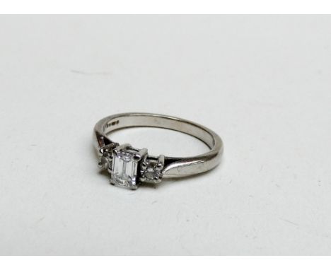 A platinum and diamond 3 stone ring set with a princess cut diamond to the centre flanked each side by claw set brilliant cut