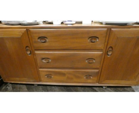 An Ercol sideboard fitted 3 centre drawers and cupboard each end 