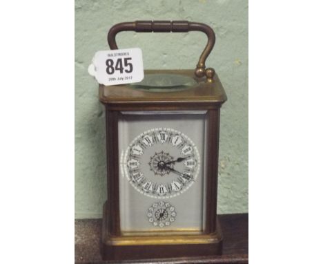 A brass carriage clock in brass and glass case with grey enamel dial fitted with alarm      No serial number seen 