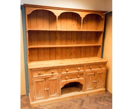 A 6' Victorian stripped pine kitchen dresser with shelf back, cupboards and drawers under with bun handles