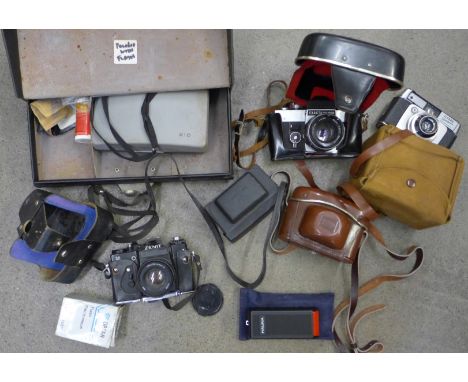 A collection of cameras including Exakta, Bella, Polaroid, Zenit, etc.