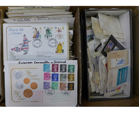 A box of Royal Mail first day covers and a box of loose stamps