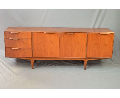 A MCINTOSH AND CO TEAK SIDEBOARD, with double cupboard doors revealing a shaped shelf, flanked by three graduated drawers and