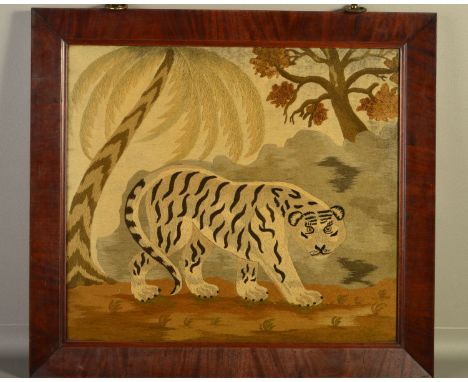 AN EARLY 19TH CENTURY NEEDLEWORK PICTURE OF A TIGER PROWLING IN A LANDSCAPE WITH PALM TREE, another tree in the top right cor
