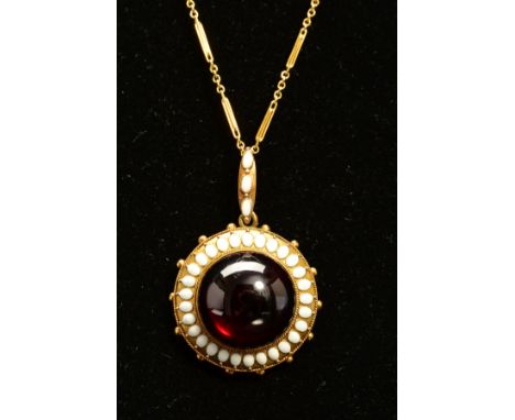 A MID VICTORIAN GOLD GARNET AND WHITE ENAMEL PENDANT, centring on a large cabochon circular garnet measuring approximately 17