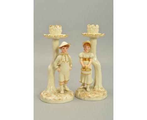 A PAIR OF ROYAL WORCESTER KATE GREENWAY STYLE FIGURAL CANDLESTICKS, modelled by James Hadley, white with gilt details, impres