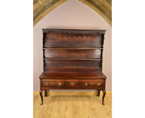 A GEORGE III OAK AND MAHOGANY BANDED DRESSER, the back with moulded cornice above a wavy frieze, enclosed back with three she