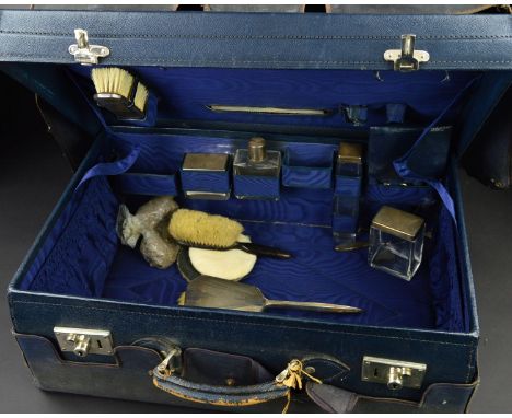 A GEORGE V BLUE LEATHER SUITCASE, with canvas outer cover, the case interior with water marked blue silk interior and fitted 