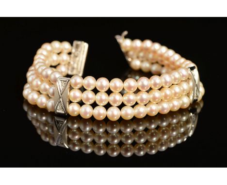 A MODERN 18CT WHITE GOLD, THREE ROW CULTURED PEARL AND DIAMOND BRACELET, each row intersected by a rectangular satin finish p