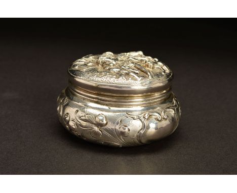 A LATE 19TH CENTURY CONTINENTAL SILVER TRINKET BOX, of circular form, the hinged cover repousse decorated with a scene of fig
