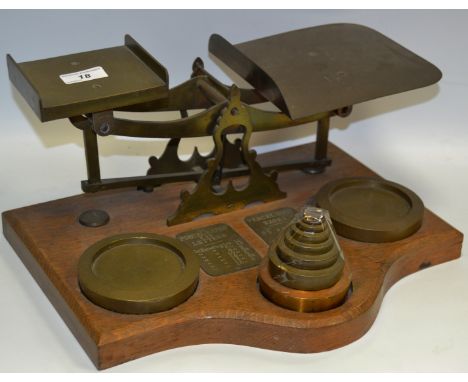 A large brass counter top postal scale, 40z to 11Lbs, with tower weights, shaped  oak base, c.1930s