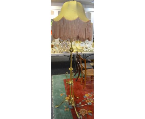An early 20th century brass standard lamp, the central column knopped throughout with girdles and terminating in a globular r