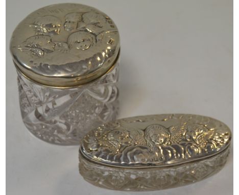 An Edwardian silver topped dressing table jar, embossed with Reynolds Angels; another, Birmingham 1907 and 1908 (2)