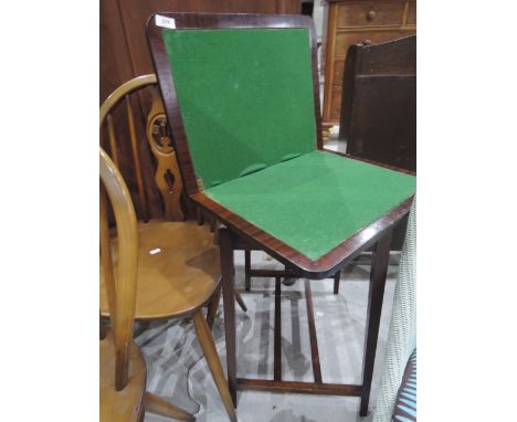 An early 20th Century mahogany fold over card table on square legs