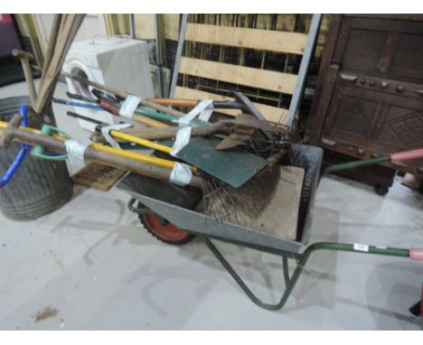 A vintage wheelbarrow and selection of tools